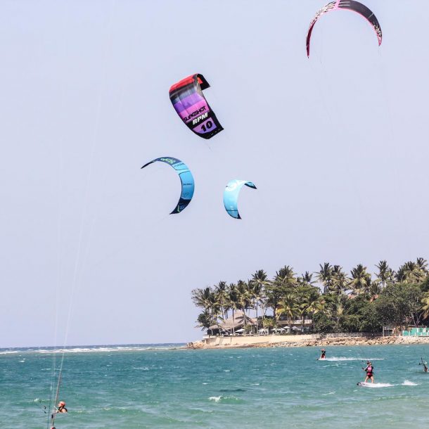 Female Kitesurfer riding in the turquoise waters of Cabarete, amongst other Kitesurfers during the Kite Sisters Women Kiteboarding Camp in Cabarete