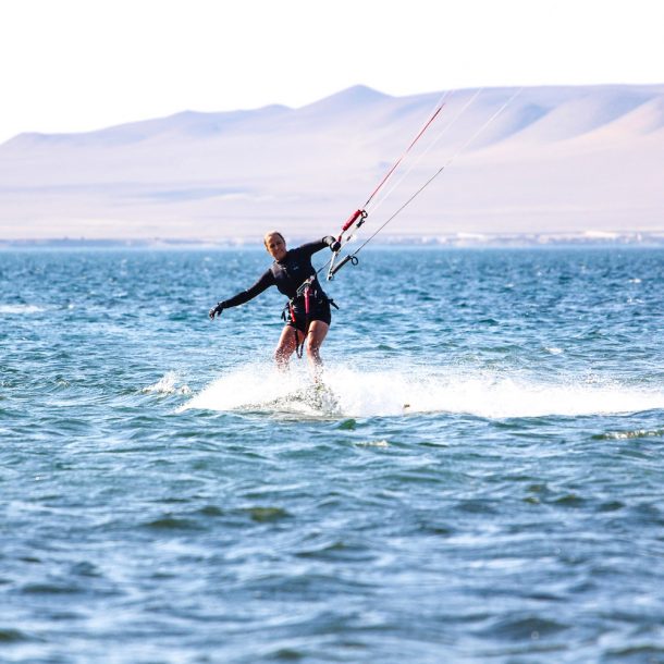 Female Kitesurfer riding toeside in Paracas Bay during the Kite Sisters Women Kiteboarding Camp